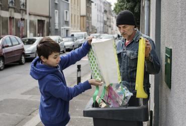Geste de tri des déchets dans la poubelle jaune